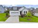 Charming white home with a two-car garage, complemented by lush green lawn and landscaping at 2537 Cedar Hedge Ct, Apex, NC 27523