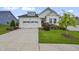 Charming white home with a two-car garage, manicured lawn, and inviting curb appeal on a sunny day at 2537 Cedar Hedge Ct, Apex, NC 27523