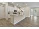 Modern kitchen features an island, white cabinets and quartz countertops at 2537 Cedar Hedge Ct, Apex, NC 27523