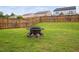 Spacious backyard with green grass, wood fence, and a fire pit at 2604 Fortrose Ln, Fuquay Varina, NC 27526