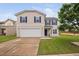 Charming two-story home with a well-manicured lawn, attached two-car garage and blue shutters at 2604 Fortrose Ln, Fuquay Varina, NC 27526