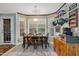 Bright dining area features a wooden table with six chairs, a pendant light, and natural light from the surrounding windows at 275 Eagle Stone Rdg, Youngsville, NC 27596