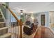 Cozy living room with a stone fireplace, ceiling fan, and staircase at 275 Eagle Stone Rdg, Youngsville, NC 27596
