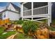 Landscaped backyard featuring a stone retaining wall, wooden steps, and a screened-in porch at 290 Quarter Gate Trce, Chapel Hill, NC 27516
