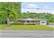 Traditional brick home featuring a covered front porch, lush lawn, and an attached garage at 3114 Alabama Ave, Durham, NC 27705
