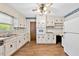 Functional kitchen showcasing white appliances, updated flooring, and ample cabinet space at 3114 Alabama Ave, Durham, NC 27705