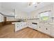 Bright kitchen featuring white cabinetry, wood-look flooring, and a large window at 3114 Alabama Ave, Durham, NC 27705