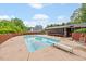 Refreshing backyard pool with diving board, surrounded by a fence, trees, screened porch and lush landscaping at 3114 Alabama Ave, Durham, NC 27705