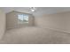 This spacious attic area features neutral walls, carpet, and a window providing natural light at 319 Brinkley Cir, Mebane, NC 27302