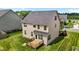 Large backyard with a wooden deck and green lawn surrounding the two-story home at 319 Brinkley Cir, Mebane, NC 27302