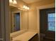 Bright bathroom featuring a large mirror, vanity with a solid countertop and window for natural lighting at 319 Brinkley Cir, Mebane, NC 27302