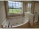 Bathroom featuring garden tub with shower and a large window providing natural light at 319 Brinkley Cir, Mebane, NC 27302