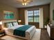Serene bedroom with a plush bed, soft lighting, and a large window overlooking the backyard, perfect for relaxation at 319 Brinkley Cir, Mebane, NC 27302