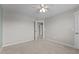 This bedroom features neutral walls, carpet, a ceiling fan, and a doorway leading to another room at 319 Brinkley Cir, Mebane, NC 27302
