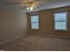 Spacious bedroom with neutral tones, ceiling fan, and natural light from two windows at 319 Brinkley Cir, Mebane, NC 27302