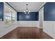 Dining room with dark wood floors, chair rail, large window, and chandelier at 319 Brinkley Cir, Mebane, NC 27302