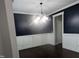 Modern dining area featuring dark blue walls with white wainscoting, hardwood floors and modern chandelier at 319 Brinkley Cir, Mebane, NC 27302