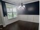 Bright dining room featuring white wall paneling, dark blue walls, hardwood floors, and a modern chandelier at 319 Brinkley Cir, Mebane, NC 27302