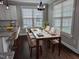 Bright dining area with a glass-top table set for six, complemented by natural light streaming through large windows at 319 Brinkley Cir, Mebane, NC 27302