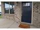 Inviting front entrance with a stylish navy door, a welcome mat, and a charming brick facade at 319 Brinkley Cir, Mebane, NC 27302