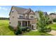 Charming two-story home with a well-manicured lawn, landscaped garden, and welcoming front porch at 319 Brinkley Cir, Mebane, NC 27302