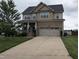 Charming two-story home with a wide driveway and attached two-car garage, complemented by a lush green lawn at 319 Brinkley Cir, Mebane, NC 27302
