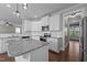 Well-lit kitchen featuring white cabinets, granite countertops, stainless steel appliances, and an island at 319 Brinkley Cir, Mebane, NC 27302