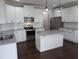Modern kitchen with white cabinets, stainless steel appliances, granite countertops, and an island providing ample workspace and storage at 319 Brinkley Cir, Mebane, NC 27302