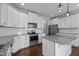 Bright kitchen features white cabinetry, stainless steel appliances, granite countertops and modern lighting at 319 Brinkley Cir, Mebane, NC 27302