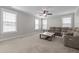Spacious living room features ceiling fan, comfortable seating, carpet, and multiple windows at 319 Brinkley Cir, Mebane, NC 27302