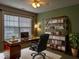 Office with a glossy desk, black leather chair, large window, and a wooden bookshelf with décor at 319 Brinkley Cir, Mebane, NC 27302