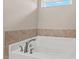Close-up of a soaking tub with tile surround and sleek fixtures at 328 Avery Meadows Dr, Smithfield, NC 27577
