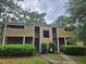 Exterior view of a tan two-story townhome with brick facade on the lower level at 3559 Mill Run, Raleigh, NC 27612
