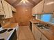 This kitchen features white cabinets, laminate countertops, a stainless steel double sink, and a view to the backyard at 3559 Mill Run, Raleigh, NC 27612