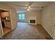 Cozy living room features a fireplace, ceiling fan, and large windows offering natural light and an adjacent kitchen at 3559 Mill Run, Raleigh, NC 27612