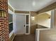 A covered entryway with a white door, brick column, and wood-look flooring at 3559 Mill Run, Raleigh, NC 27612
