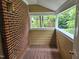 Enclosed porch with brick siding, wood flooring, and exterior light fixture at 3559 Mill Run, Raleigh, NC 27612