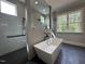 Luxurious bathroom featuring a soaking tub, a glass-enclosed shower, and contemporary finishes at 3632 Rail Overlook Dr, New Hill, NC 27562