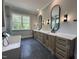 Bright bathroom with dual vanities, modern lighting, and a freestanding soaking tub at 3632 Rail Overlook Dr, New Hill, NC 27562