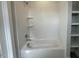 Bright bathroom featuring a bathtub, tiled walls, and built-in shelving at 3632 Rail Overlook Dr, New Hill, NC 27562