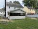 Backyard view of the screened-in porch of this home with a black chimney at 3825 Old Coach Rd, Raleigh, NC 27616