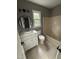 Neutral bathroom featuring a white vanity with modern round mirror, window, and combined tub and shower at 3825 Old Coach Rd, Raleigh, NC 27616