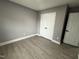 Clean bedroom featuring gray walls, white trim, vinyl floors, closet, and paneled interior doors at 3825 Old Coach Rd, Raleigh, NC 27616