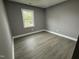 Small bedroom featuring gray walls, white trim, a window, vinyl floors, and simple decor at 3825 Old Coach Rd, Raleigh, NC 27616