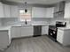 Modern kitchen featuring all-white cabinetry, stainless steel appliances, and contemporary finishes at 3825 Old Coach Rd, Raleigh, NC 27616