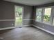 Bright living room featuring gray walls, white trim, and large windows offering plenty of natural light at 3825 Old Coach Rd, Raleigh, NC 27616
