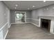 Spacious living room with updated flooring, neutral paint, and a stone fireplace at 3825 Old Coach Rd, Raleigh, NC 27616
