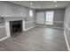 Bright living room featuring updated flooring, neutral paint, large windows, and a stone fireplace at 3825 Old Coach Rd, Raleigh, NC 27616
