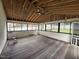 Spacious sunroom with wood floors, exposed rafters, and a wall of windows overlooking the yard at 3825 Old Coach Rd, Raleigh, NC 27616
