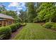 Lush green backyard featuring manicured lawn and mature trees, offering a serene and private outdoor space at 3919 Wentworth Dr, Durham, NC 27707
